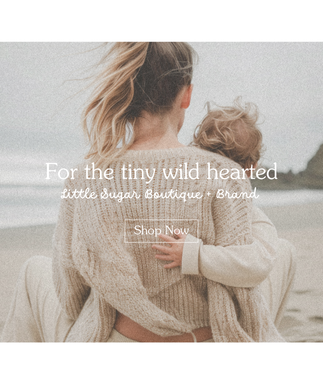 Woman and child wrapped in a blanket on a beach with text overlay.
